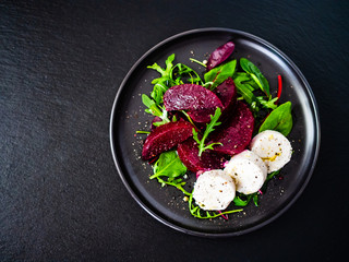  Beetroot salad with goat cheese on black stone plate