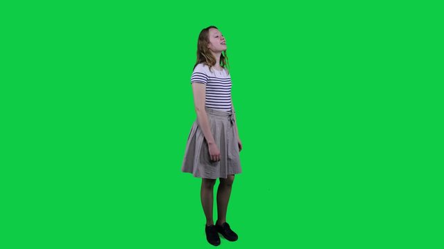 Teenage girl singing, vibing to music in front of a green screen