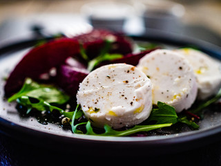  Beetroot salad with goat cheese on black stone plate