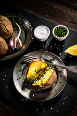 Jacket potatoes on black stone board