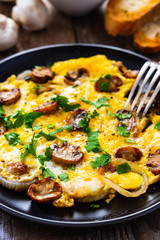 Breakfast - omelette with champignon on wooden background