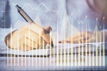 Multi exposure of woman's hands making notes with forex graph hologram. Concept stock market...