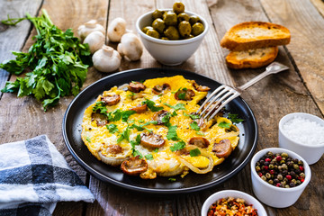 Breakfast - omelette with champignon on wooden background