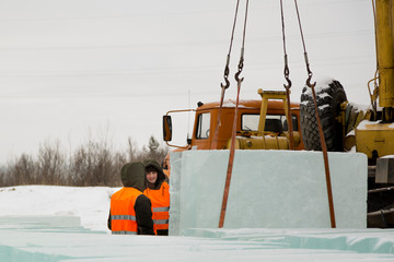 Slingers in special winter overalls for shipment of ice blocks