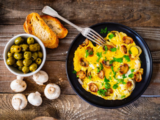 Breakfast - omelette with champignon on wooden background