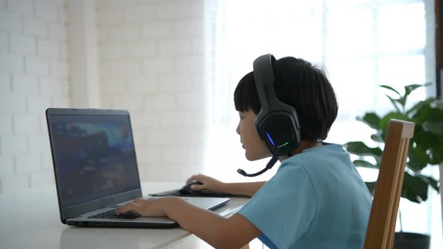 Family concept. The boy is playing computer games at home. 4k Resolution.