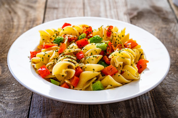 Pasta with vegetables on wooden background