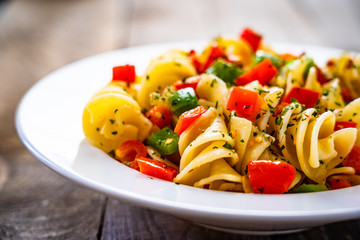 Pasta with vegetables on wooden background
