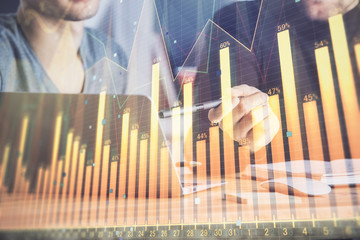 Forex graph with businessman typing on computer in office on background. Concept of analysis. Double exposure.