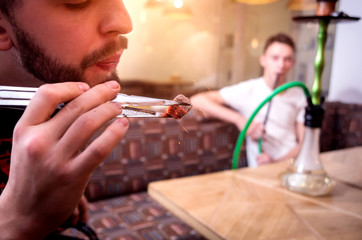 Cooking hookah in the bar. Young man with hookah in restaurant