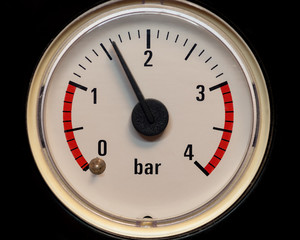 The pressure gauge dial with red band to control the water pressure. Closeup.