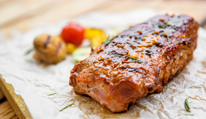 grilled meat ribs with vegetables on wooden table