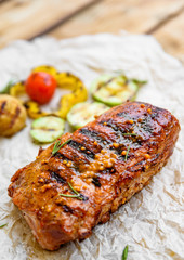 grilled meat ribs with vegetables on wooden table