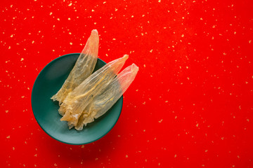 A plate of golden yellow mucilan caramel on a red background