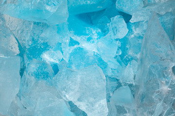 Pieces of crushed blue ice glass cracks background texture. close-up frozen water