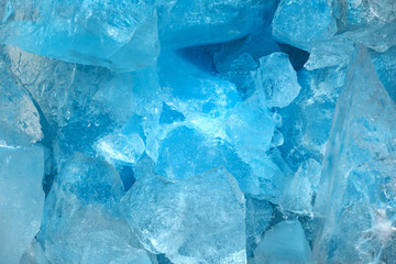 Pieces of crushed blue ice glass cracks background texture. close-up frozen water
