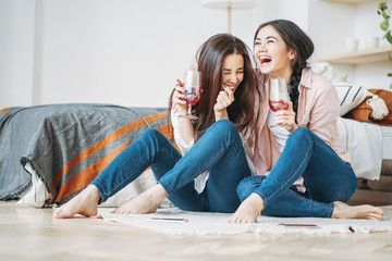 Young carefree laughing brunette girls friends in casual with glasses of wine having fun together...