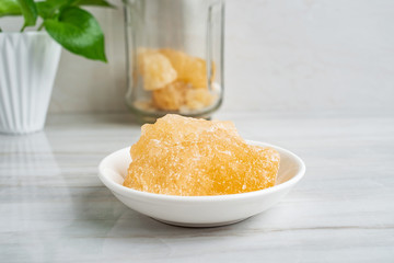 A dish of yellow rock sugar on the kitchen tile countertop