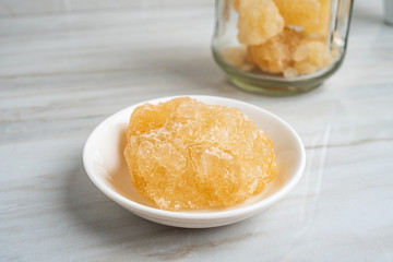 A dish of yellow rock sugar on the kitchen tile countertop