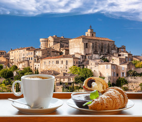 Coffee with croissants against Gordes village in Provence, France