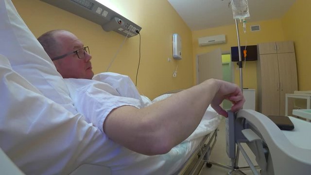The patient puts off the smartphone, lowers the headboard of the bed, removes his glasses and goes to bed.