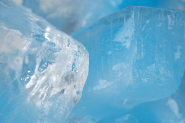 Pieces of crushed blue ice glass cracks background texture. close-up frozen water