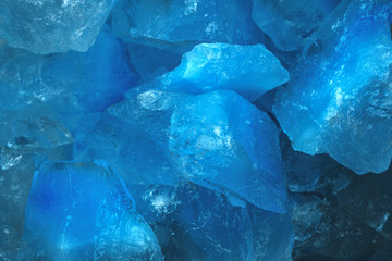 Pieces of crushed blue ice glass cracks background texture. close-up frozen water