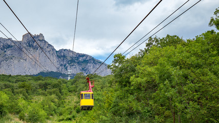 Beautiful aerial view of the mountains whose slopes are covered with green forest from the yellow...