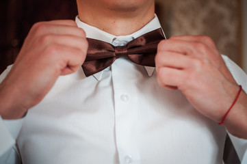 Dark red bowtie on the grooms neck