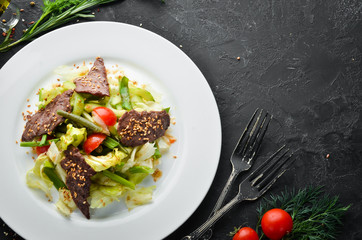 Beef salad with beans and fresh vegetables. Top view. Free space for your text.