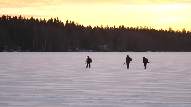 Slow motion, three survivors wander on frozen lake, harsh arctic climate