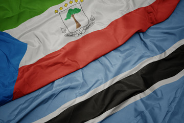 waving colorful flag of botswana and national flag of equatorial guinea.