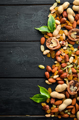 Assorted nuts on the old black background. Top view. Free space for your text.