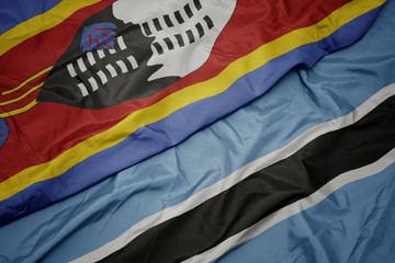 waving colorful flag of botswana and national flag of swaziland.