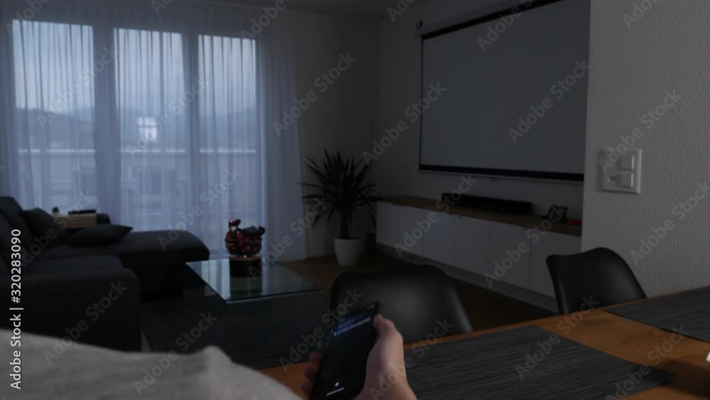 Poster man controls the lighting in his living room using the speech recognition of a smartphone app - smar