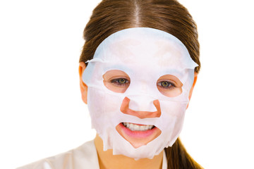 Woman applying sheet mask on face