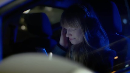 Woman crying and texting with her smartphone inside a car