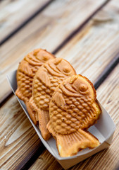 Taiyaki Japanese street food fish-shaped sweet filling waffle in box on wooden table