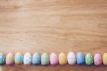 Colorful easter eggs on wooden table background vintage with copy space.