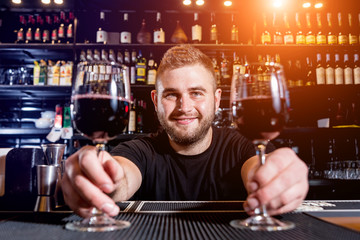 Bartender pours red wine into a glass. Sommelier. Restaurant. Nightlife