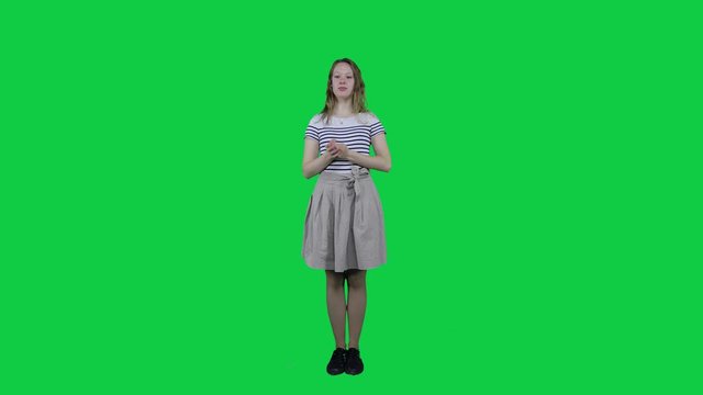 Cute teenage girl relaxing, meditating in front of a green screen