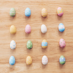 Colorful easter eggs on wooden table background with vintage toned.