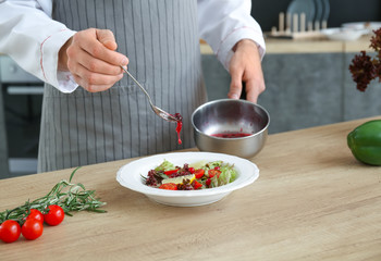 Male chef cooking in kitchen, closeup