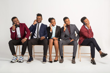 beautiful african people in suits on a white background with phones in their hands