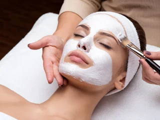 Acrylglas douchewanden met foto Schoonheidssalon Woman receiving facial mask at beauty salon
