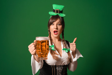 Funny young woman with beer on color background. St. Patrick's Day celebration
