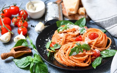 spaghetti pasta with tomatoes, parmesan cheese and basil. traditional dish of Italian cuisine. pasta recipe. selective focus