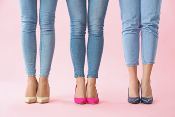 Legs of beautiful young women on color background