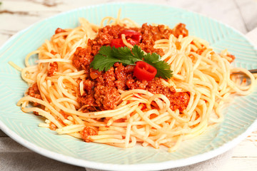 Plate with tasty pasta bolognese on table, closeup