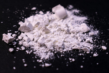  Powder from drugs on a black background. The concept of illicit trade in narcotic drugs.